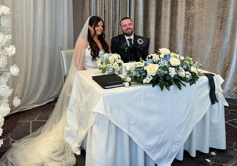 Bride and groom smile at table after signing marriage license